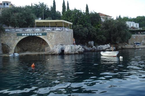 a boat in the water next to a bridge at "Azzurra Apartments in Molunat