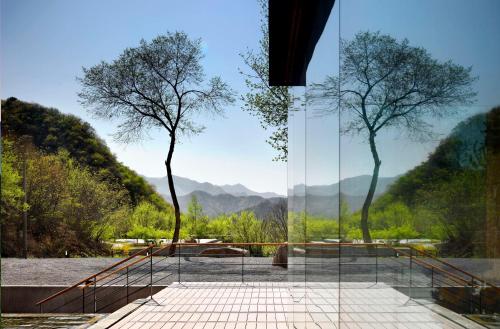 a glass house with a view of mountains at Commune by the Great Wall, in the Unbound Collection by Hyatt in Yanqing