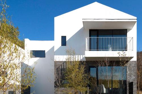 a white house with a balcony on top of it at Commune by the Great Wall, in the Unbound Collection by Hyatt in Yanqing