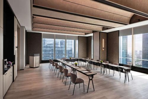 a conference room with tables and chairs and windows at Andaz Nanjing Hexi in Nanjing