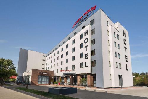 a white building with a sign on top of it at Vienna House Easy by Wyndham Bucharest Airport in Otopeni