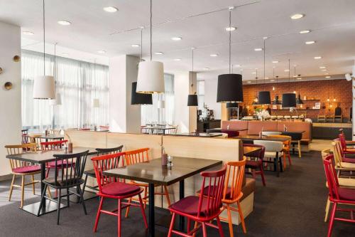 a restaurant with tables and chairs and a bar at Vienna House Easy by Wyndham Bucharest Airport in Otopeni