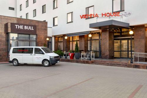 a white van parked in front of a building at Vienna House Easy by Wyndham Bucharest Airport in Otopeni