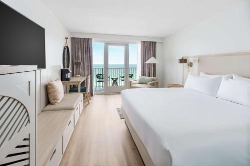 a hotel room with a bed and a view of the ocean at Beal House Fort Walton Beach, Tapestry Collection By Hilton in Fort Walton Beach