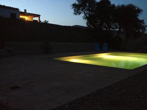 a pool with lights in a yard at night at Casitas El Paraje de Berchules in Bérchules