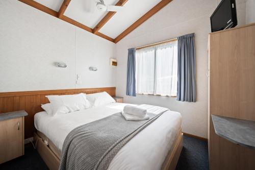 a small bedroom with a bed and a window at Bright Accommodation Park in Bright