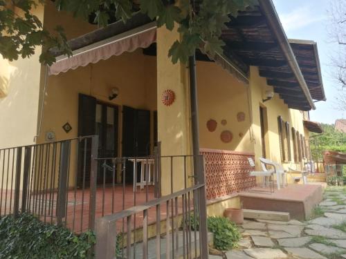 a house with a porch and a fence at Casa Martini in Pecetto