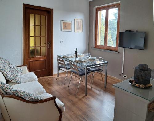 a living room with a table and chairs and a television at Casa Martini in Pecetto