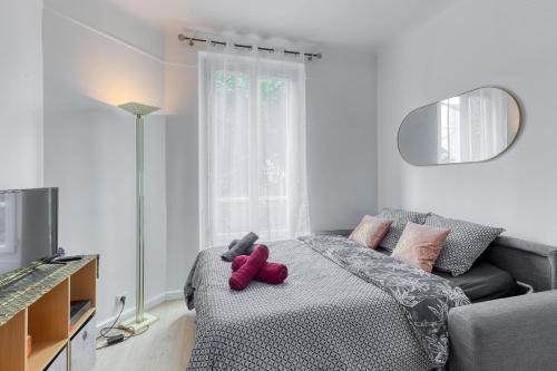 - une chambre avec un lit avec un animal rembourré dans l'établissement Studio lumineux Maisons-Laffitte, à Maisons-Laffitte