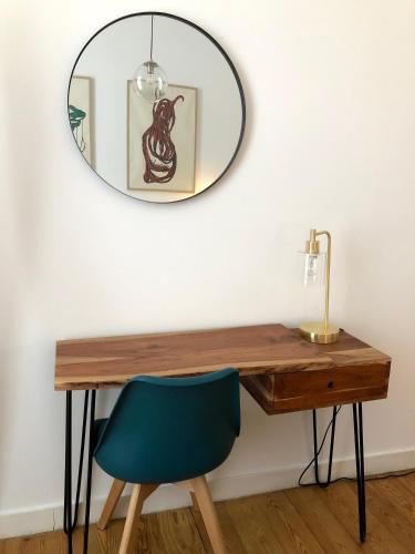 a mirror hanging above a desk with a blue chair at Living Lounge Hostel in Lisbon