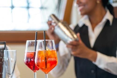 a woman is pouring wine into two wine glasses at Hotel Antiche Figure in Venice