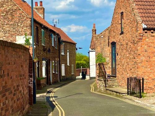 an empty street in a village with brick buildings at No. 3 A cosy spot for 4 in Cawood