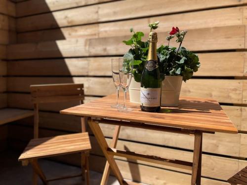 uma garrafa de champanhe sentada numa mesa de madeira com copos em No. 3 A cosy spot for 4 em Cawood