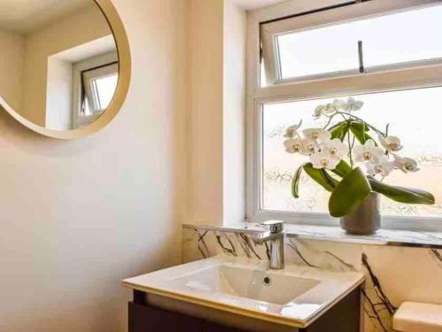 a bathroom with a sink and a mirror and a window at No. 3 A cosy spot for 4 in Cawood