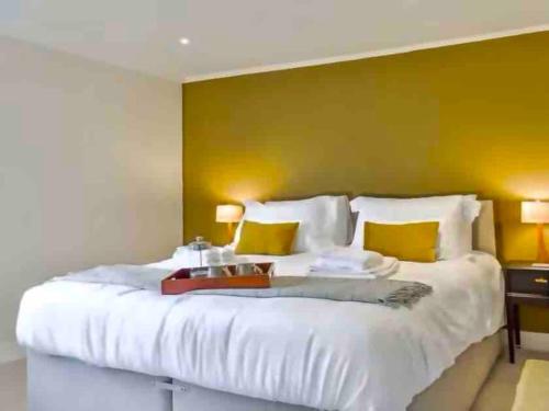 um quarto com uma grande cama branca com paredes amarelas em No. 3 A cosy spot for 4 em Cawood
