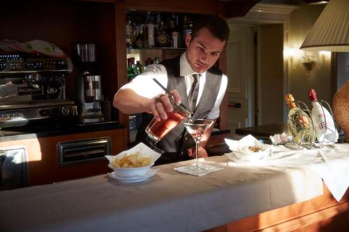 a man in a kitchen preparing a drink at Hotel Antiche Figure in Venice