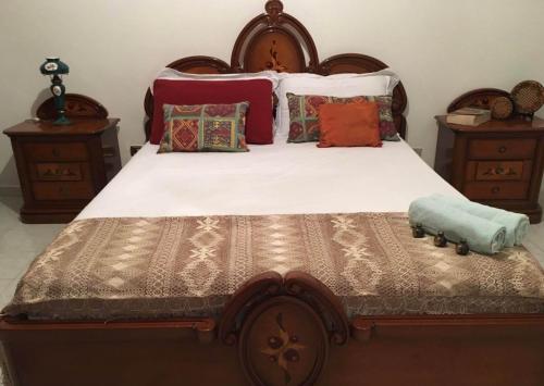 Un dormitorio con una gran cama de madera con almohadas en Twins, en Solarino