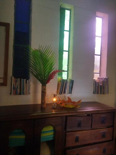 a wooden dresser with a candle and a plant on it at Casa Vitall in Líbano