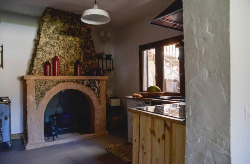 a kitchen with a fireplace in the middle of a room at Los Diezmos in Torremocha de Jarama