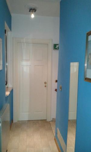 a room with a white door and a blue wall at Il Forno Dal 1922 in Bene Vagienna