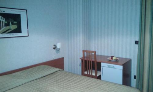 a bedroom with a bed and a table and a desk at Il Forno Dal 1922 in Bene Vagienna