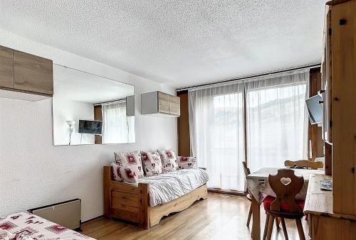 ein Schlafzimmer mit einem Bett mit rosa Kissen in der Unterkunft travelski home classic - Résidence Soyouz in Le Corbier