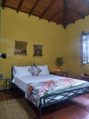 a bedroom with a bed in a yellow wall at Casa Vitall in Líbano