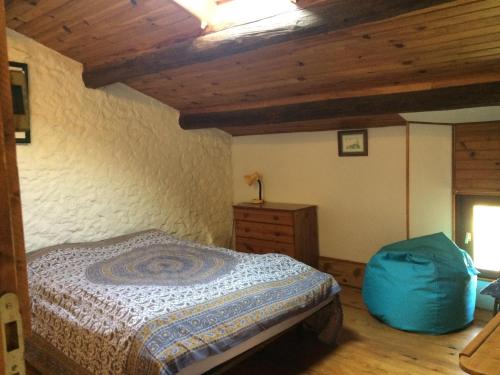 a bedroom with a bed and a blue bag at Panorama Gîtes Certes in Gaudiès