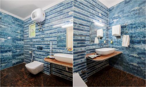 a bathroom with two sinks and a blue tiled wall at Hotel Grand Vista in Noida