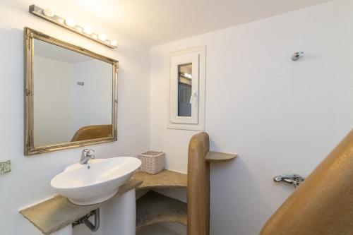 bagno con lavandino e specchio di Panormos Art Villas & Suites a Panormos