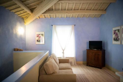 a living room with a couch and a television at Turchi Farm - Locanda della Luna & Antico Frantoio in Longiano