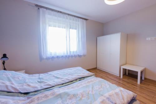 a bedroom with a bed and a window at Apartamenty u Ewy in Bodzentyn