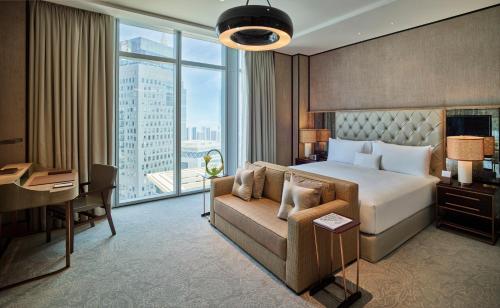 a bedroom with a bed and a couch and a desk at Waldorf Astoria Dubai International Financial Centre in Dubai