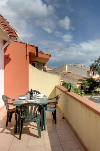 a patio with a table and chairs on a balcony at Residence Oasi Anfiteatro in Porto Ottiolu