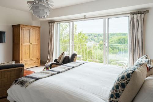 um quarto com uma cama grande e uma janela grande em Asman em Salcombe