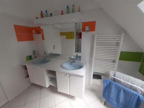 une salle de bain avec deux lavabos et un miroir dans l'établissement Les Aulnays, à Arnage