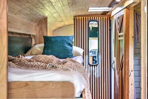 ein Schlafzimmer mit einem Bett in einem winzigen Haus in der Unterkunft Skoolie Stays - Luxury American school bus conversion in Storrington