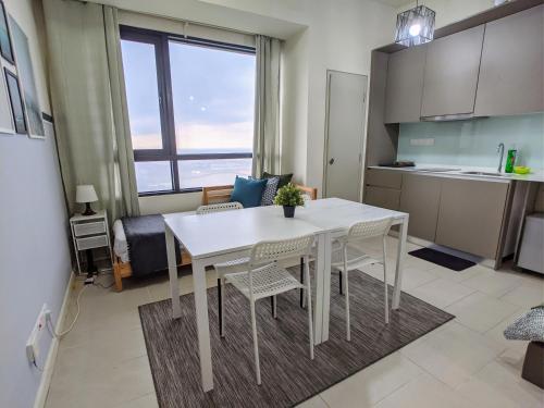 a kitchen and dining room with a white table and chairs at Tamarind Suites or D'Pulze Residence or Domain NeoCyber, click Room selection for location and pics in Cyberjaya