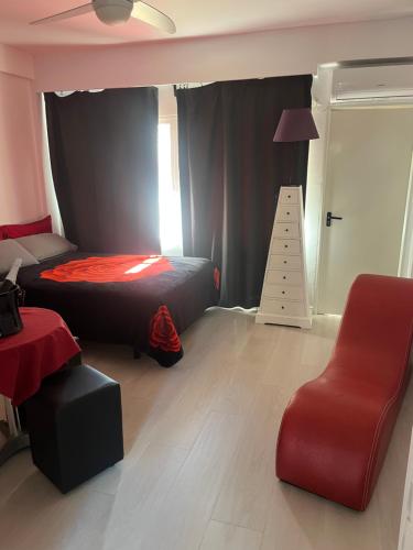 Un dormitorio con una cama y una silla roja. en Estudio ROMÁNTICO La Carihuela, en Torremolinos