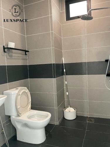 La salle de bains est pourvue de toilettes blanches et d'une fenêtre. dans l'établissement Kuching Near Batu Kawa Cozy Apartment P Residence, à Kuching