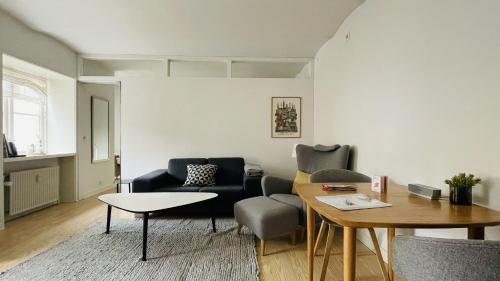 uma sala de estar com um sofá e uma mesa em ApartmentInCopenhagen Apartment 1207 em Copenhague