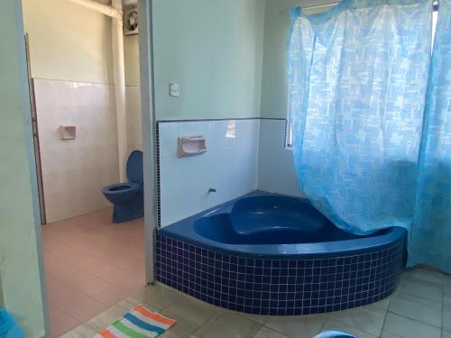 a blue tub in a bathroom with a toilet at OYO 90885 Bera Pentagon Inn in Kampong Kerayong