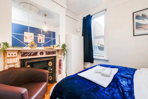 南安普敦的住宿－Southampton City Centre 1 Bed Apartment，一间卧室配有一张床、一把椅子和一个壁炉