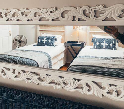 Un dormitorio con dos camas y un gran espejo. en Fairstreams 4, en Dullstroom