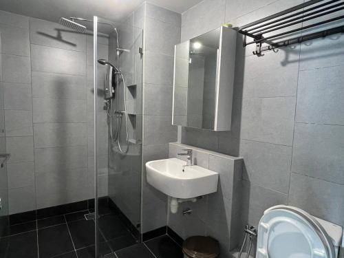 a bathroom with a sink and a shower and a toilet at Nerv Homestay JQ T1 intermediate- seaview in Kota Kinabalu