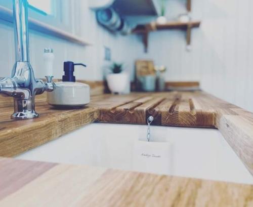 a kitchen counter with a sink with a water drop on it at Woodpecker Shepherds Hut in Boston