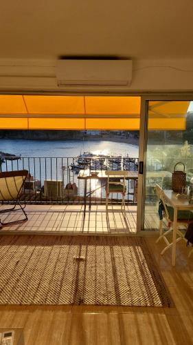 a room with a balcony with a view of a boat at Apartment in front of the sea in Llafranc