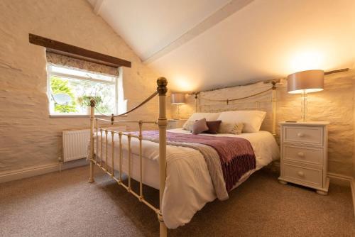 ein Schlafzimmer mit einem Bett und einem Fenster in der Unterkunft Dolly's Barn at Higher Mullacott in Ilfracombe