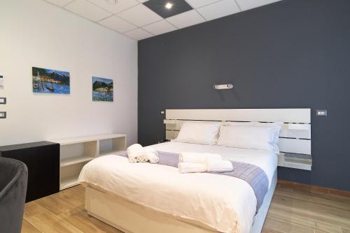 a bedroom with a large bed with white sheets at B&Bike Como Lake in Castelmarte