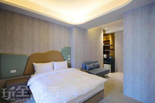 1 dormitorio con 1 cama grande y 1 silla en 礁溪玥湯溫泉旅店 en Jiaoxi